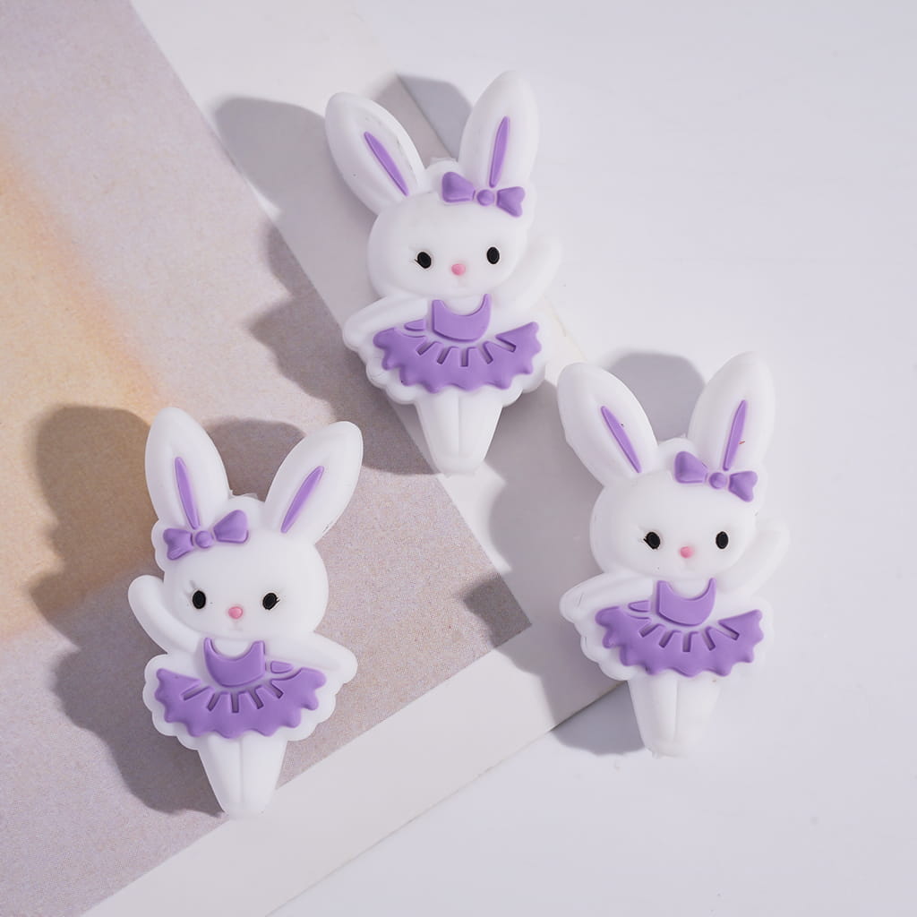Three bunny-shaped clips with purple outfits on a light background
