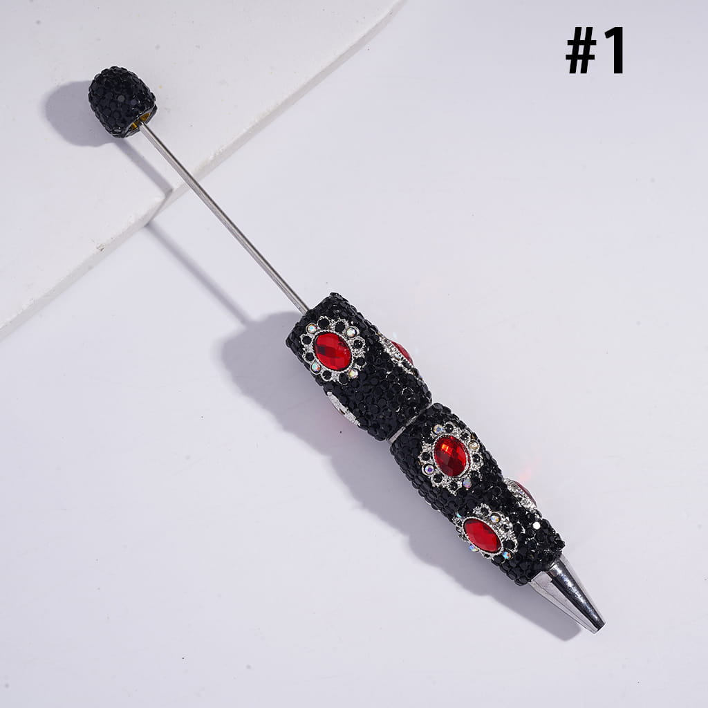 Decorative pen with black and red gemstones on a white background
