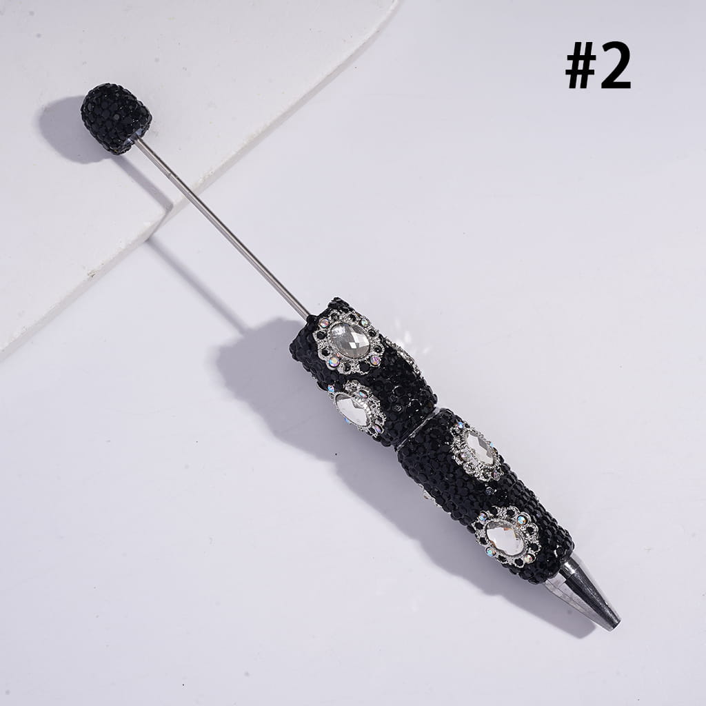 Black decorative brooch with gemstones on a white background