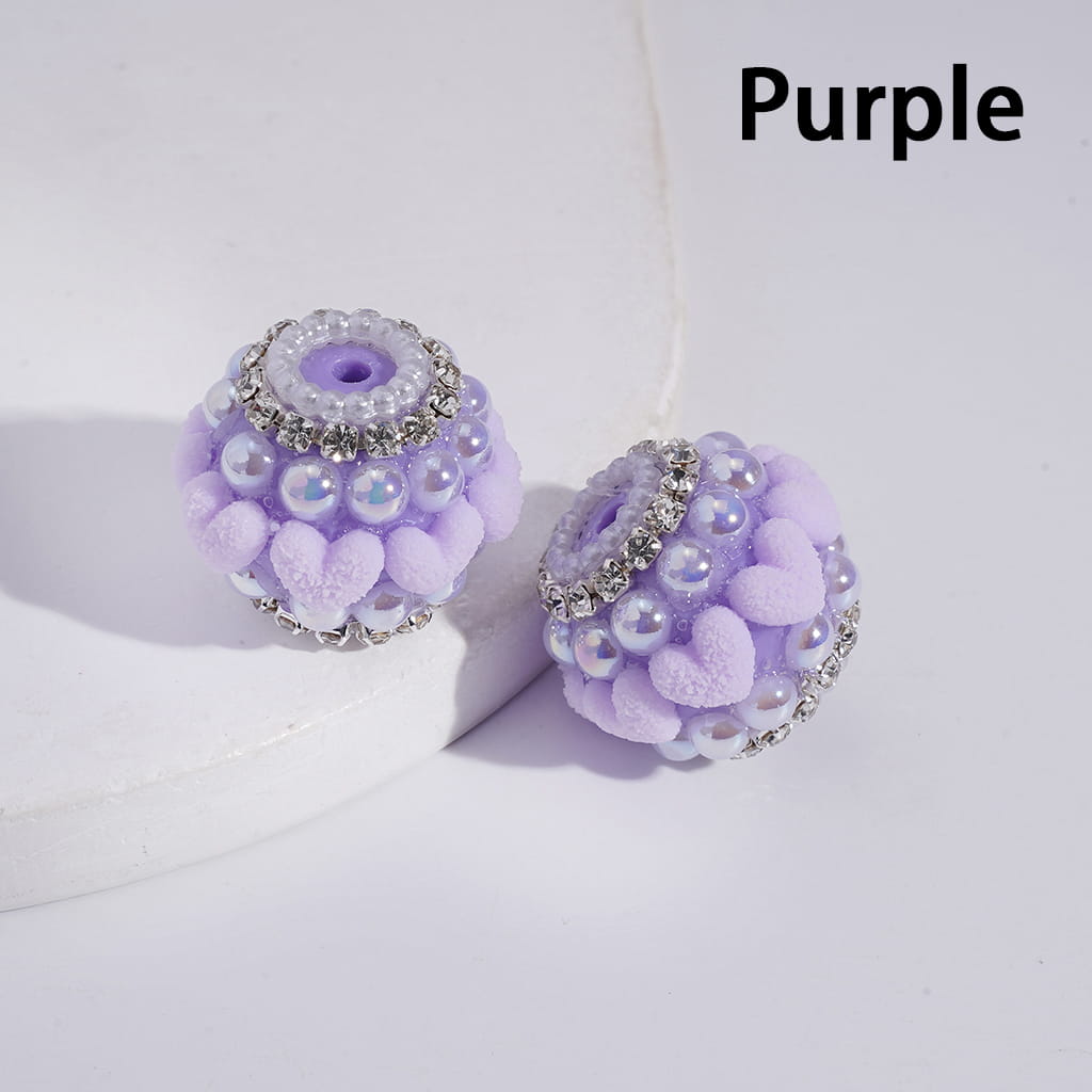 Purple decorative beads with rhinestones on a white background