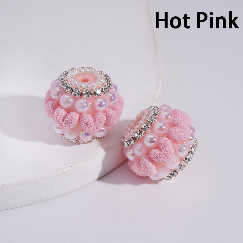 Hot pink earrings with pearl-like beads and rhinestones on a white background