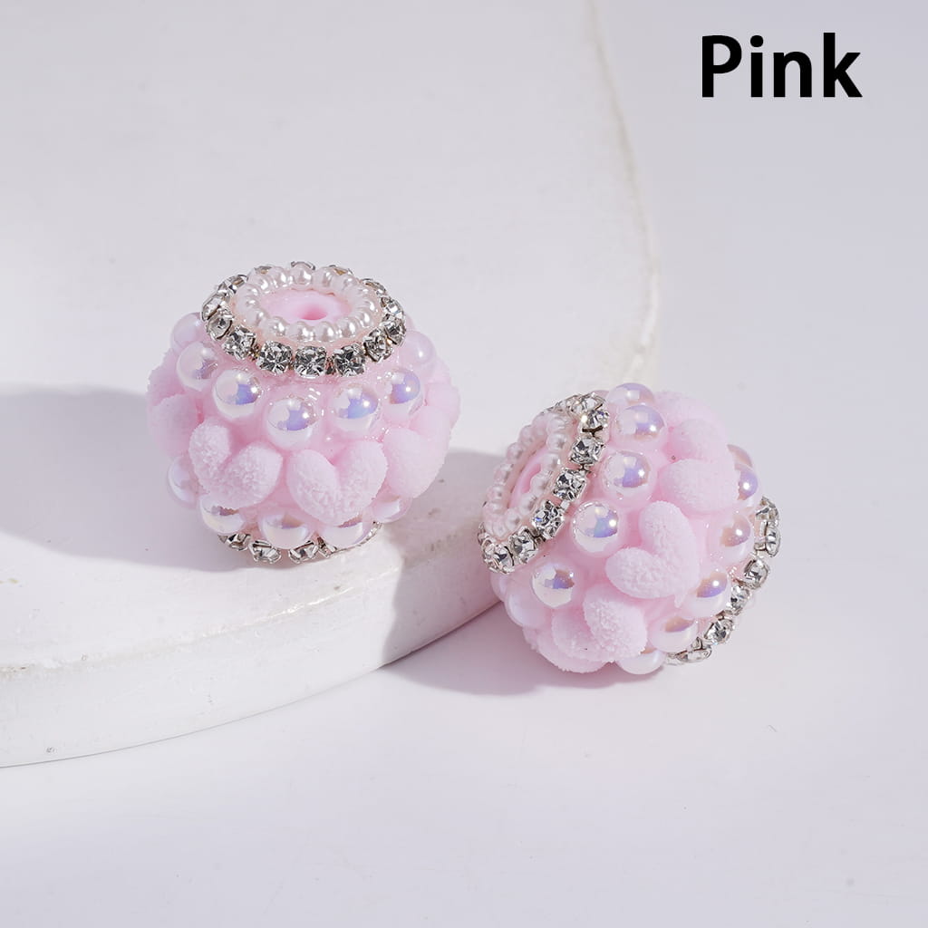 Pink earrings with floral design and rhinestones on a white background