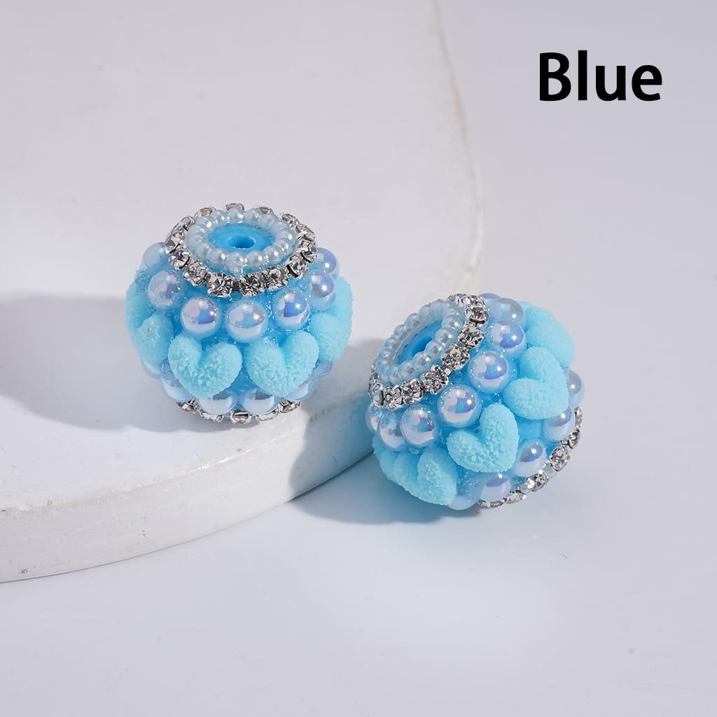 Blue spherical earrings with pearl-like beads and rhinestone accents on a white background.