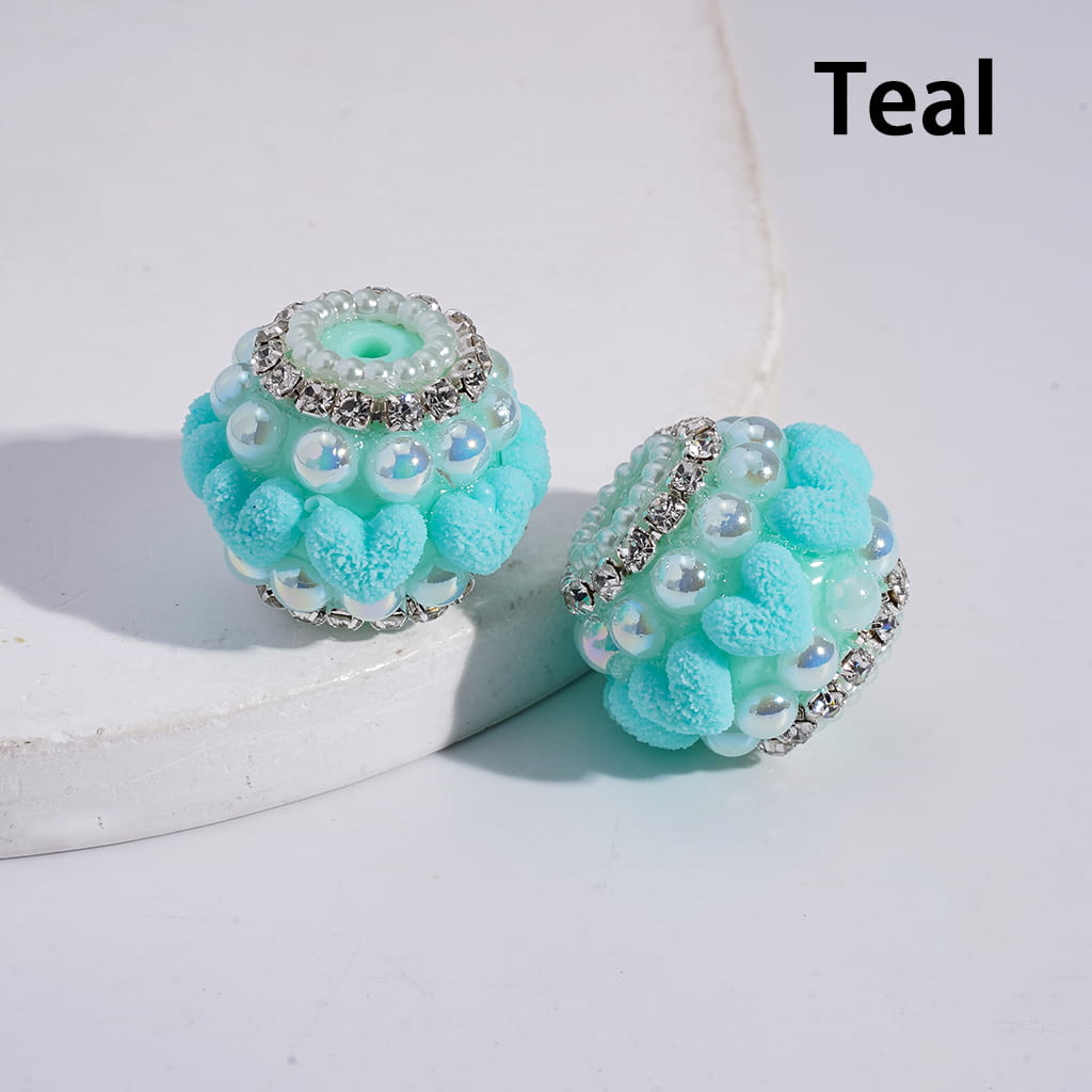 Teal earrings with decorative elements on a light background