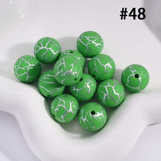Green beads with white marbled pattern on a white background