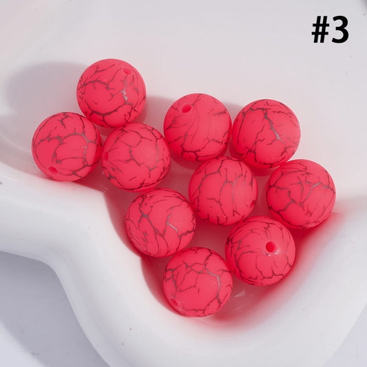 Red marbled beads on a white surface with a number 3 in the corner.