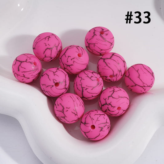 Pink marbled beads on a white dish with a white background
