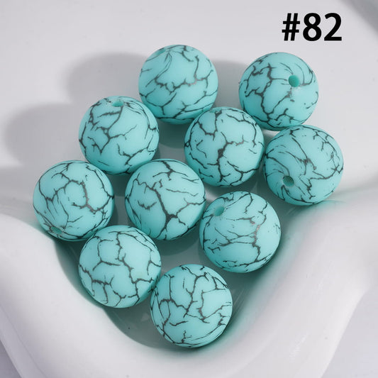 Turquoise beads with a marbled pattern on a white background