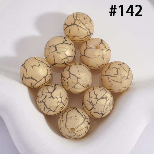 Beige beads with black marbled pattern on a white background