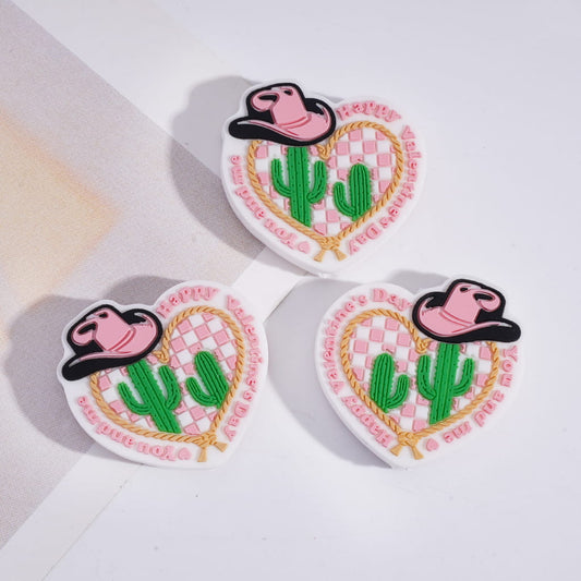 Three heart-shaped patches with a cowboy hat, cactus, and 'luv' text on a white background.