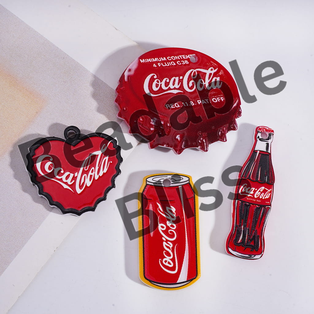 Coca-Cola themed bottle cap, can, and bottle shaped pins on a white background.