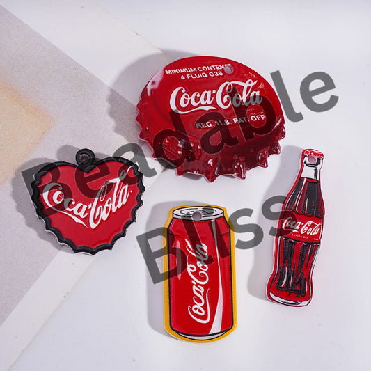 Coca-Cola themed bottle cap, can, and bottle shaped pins on a white background.