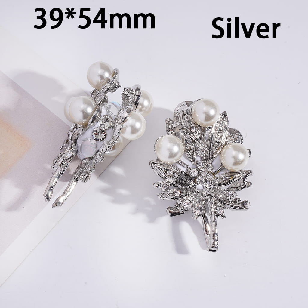 Silver brooches with pearls on a white background