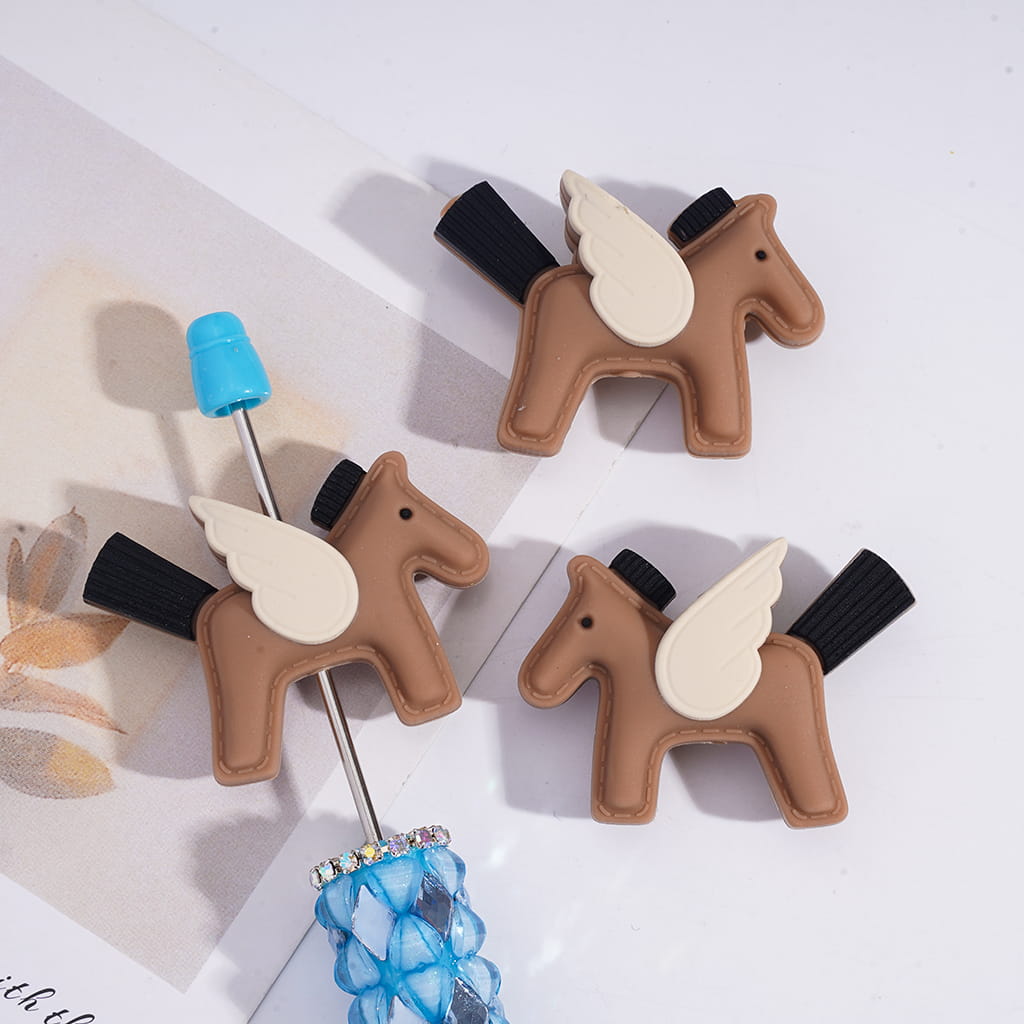 Three horse-shaped bottle openers on a white surface with a floral pattern.