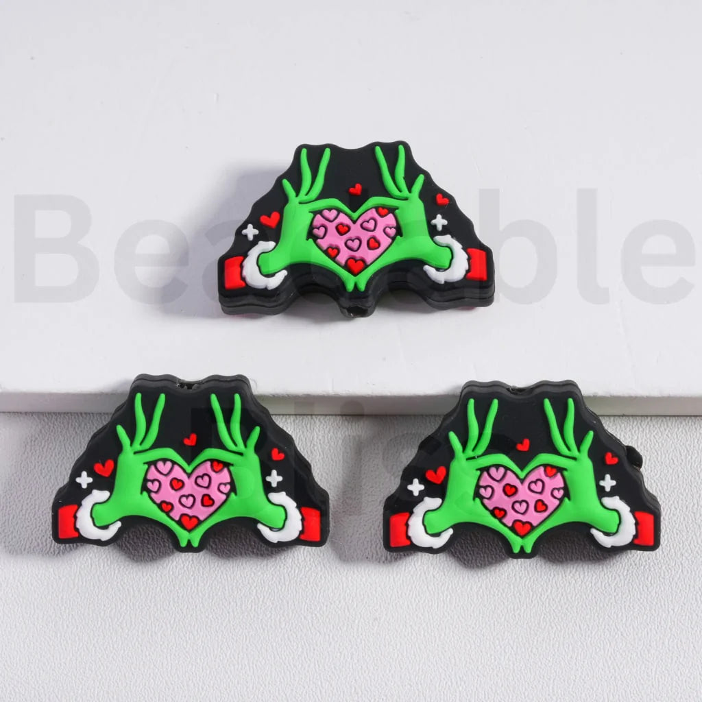 Three decorative items with green antlers and pink hearts on a white background

