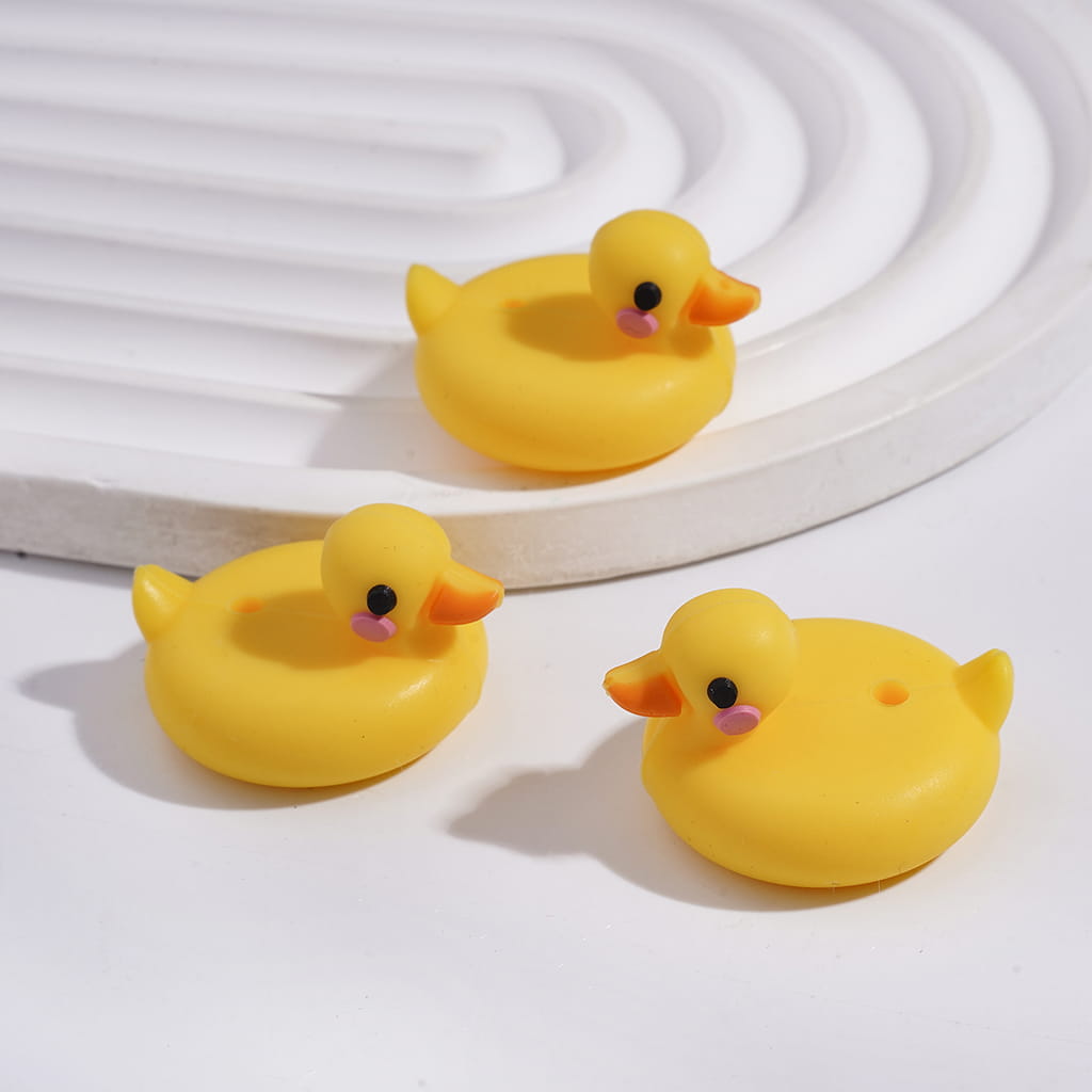 Three yellow rubber duck toys on a white background

