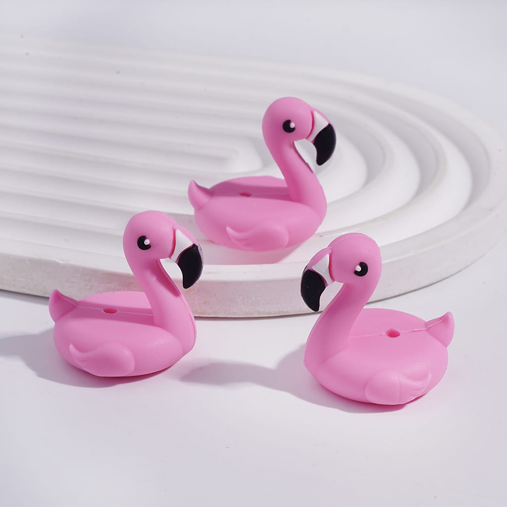 Three pink flamingo-shaped objects on a white background

