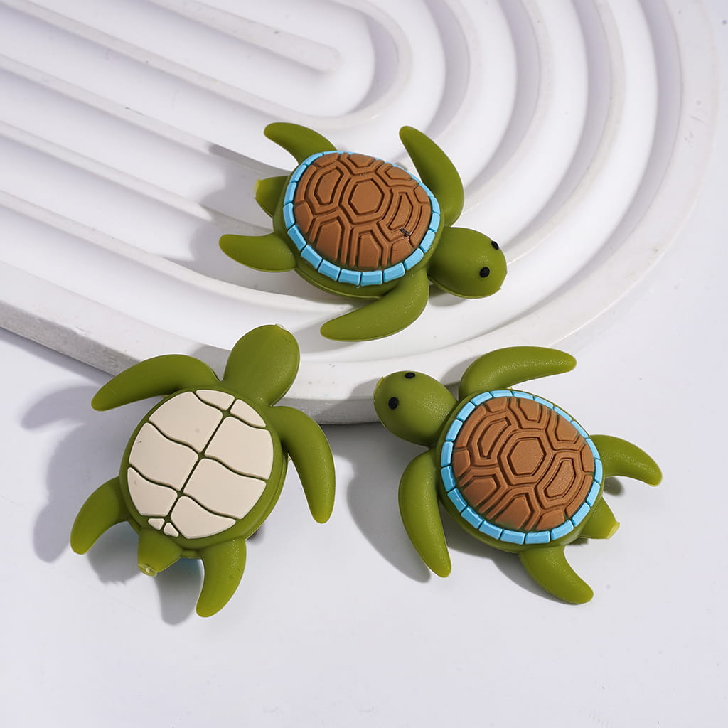 Two green turtle-shaped objects with brown and white shell patterns on a white background

