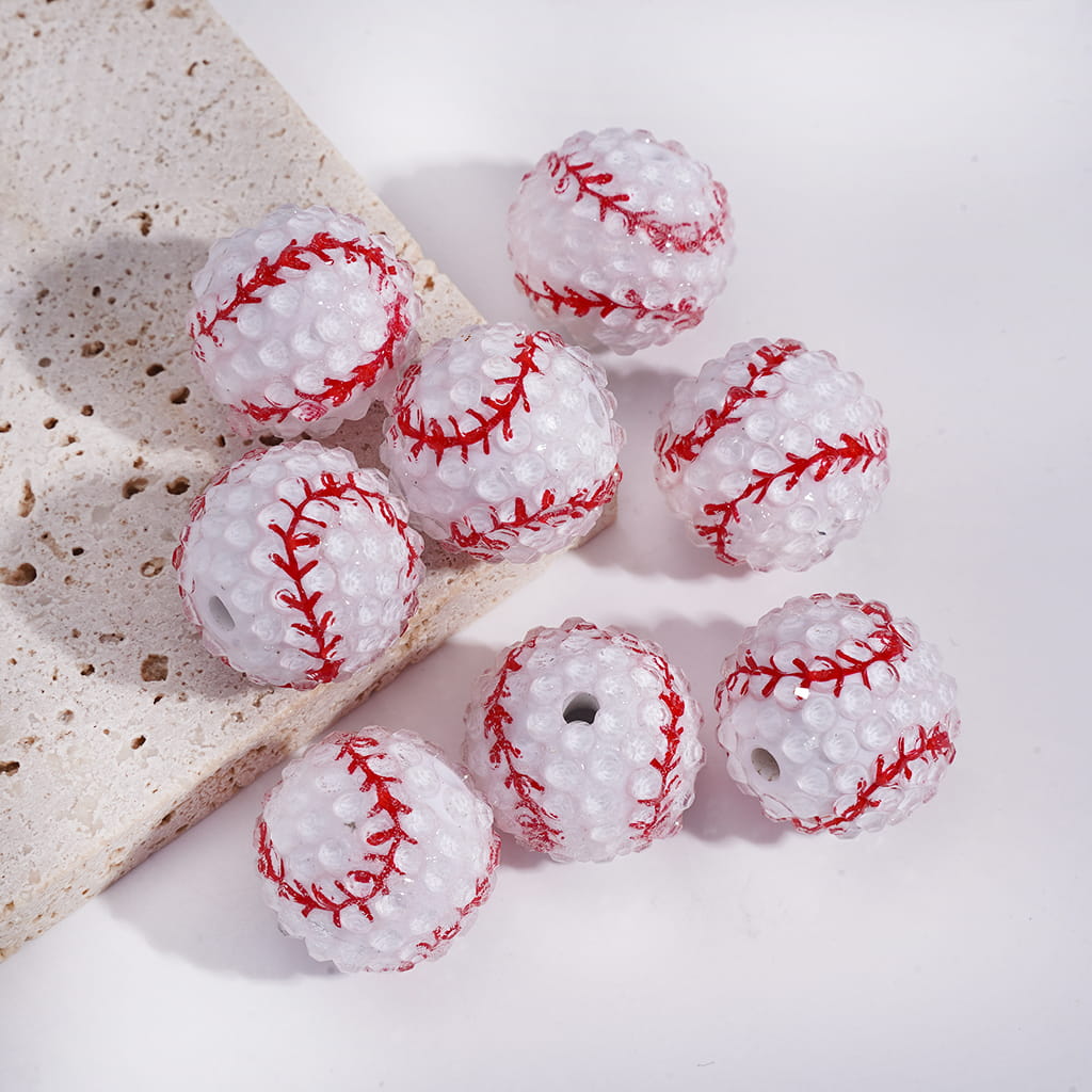Assorted sports ball beads on a heart-shaped white dish

