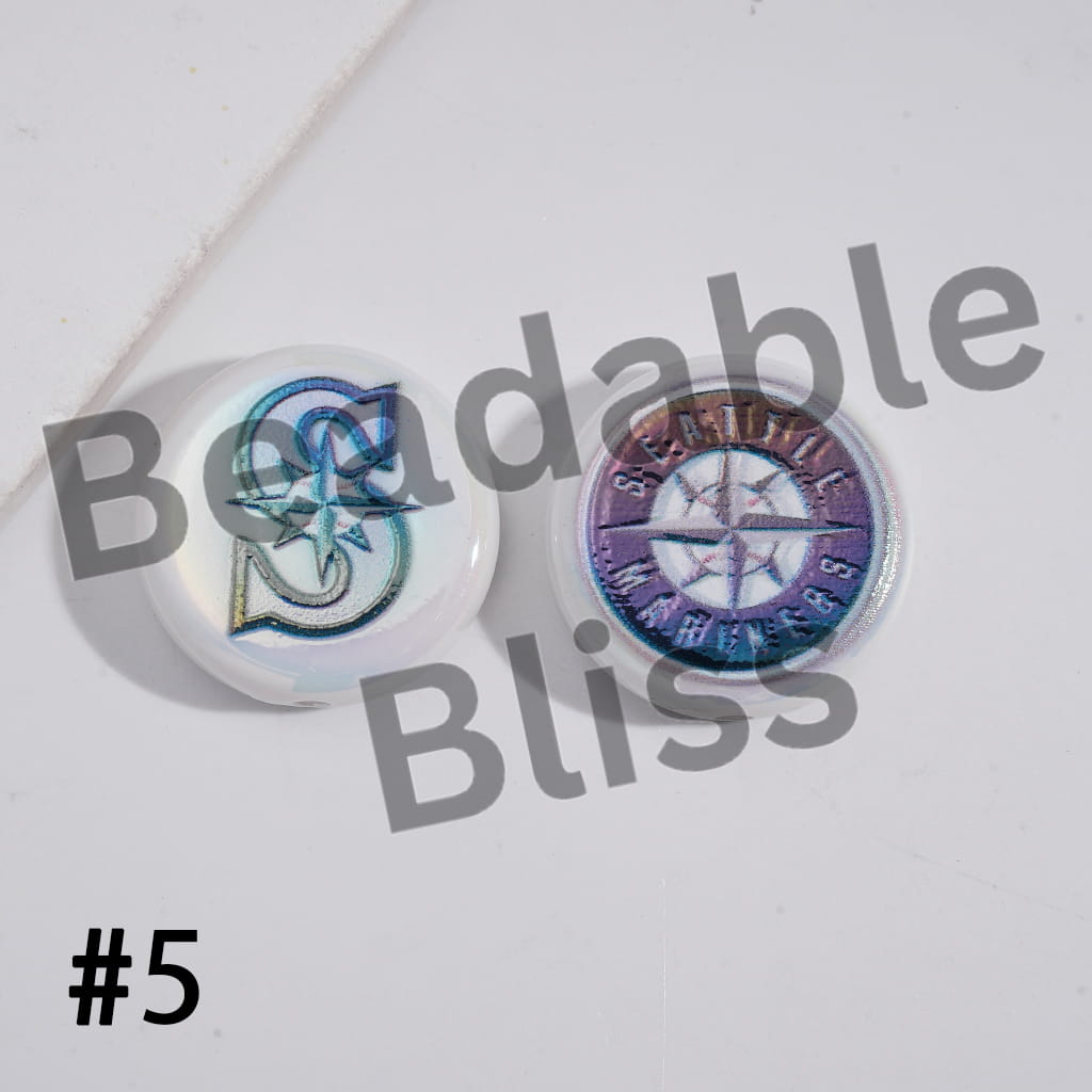 Two round, colorful buttons with star designs on a white background, branded 'Beadable Bliss'.

