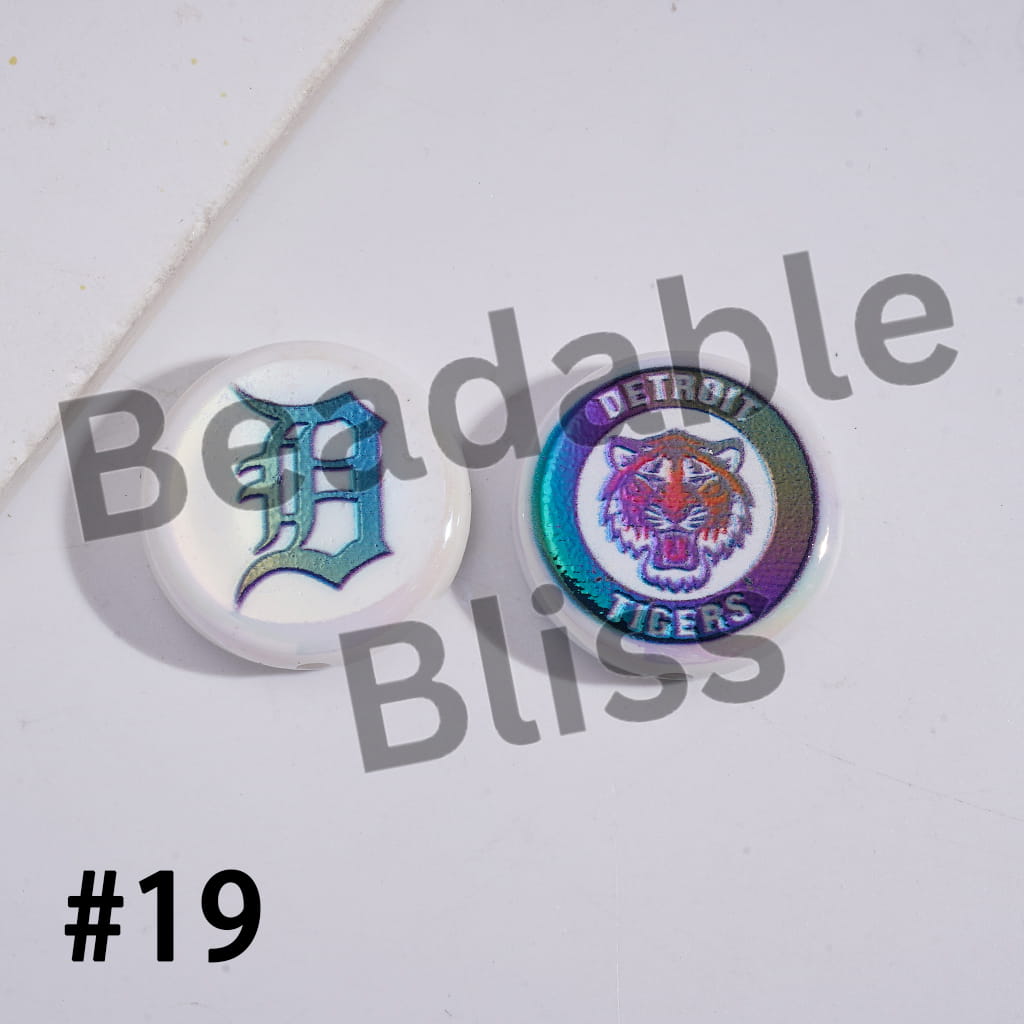 Two round pins with a letter 'D' and tiger logo on a white background with 'Bendable Bliss' branding.

