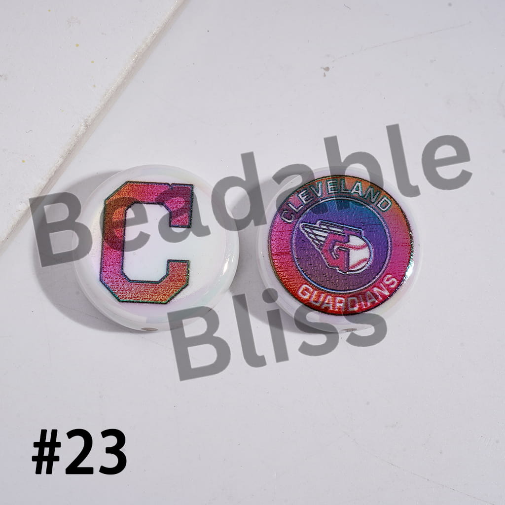 Two round pins with colorful designs on a white background, featuring the text 'Cleveland Guardians'.

