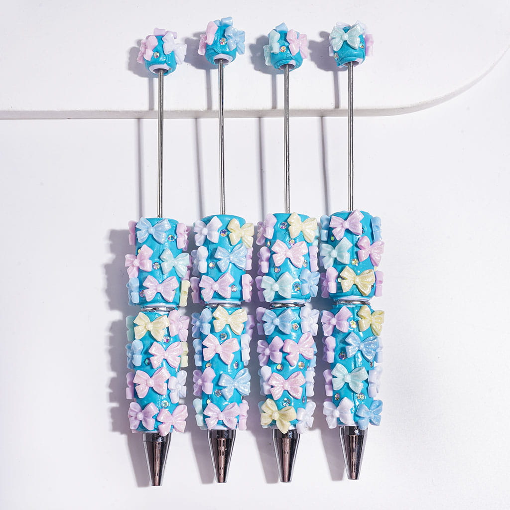 Beadable Clay Pens with Glitter Bowtie and AB Rhinestones on Blue Background