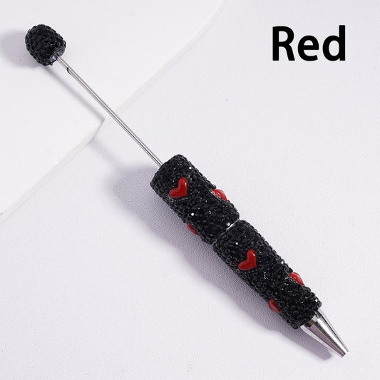 Black textured pen with red heart designs on a white background

