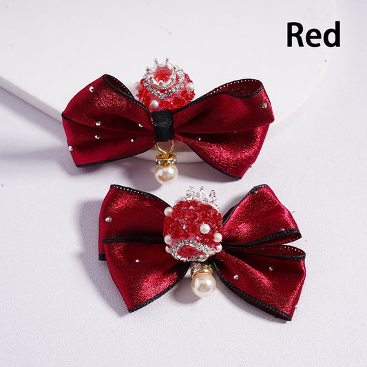 Two red satin bows with decorative centers on a white background

