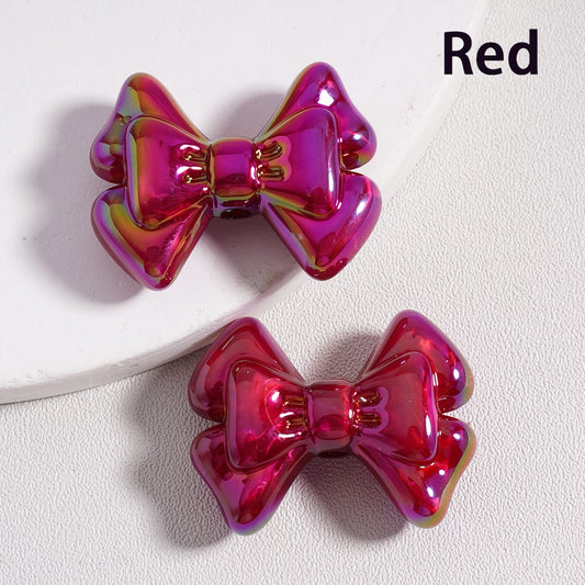 Two red metallic bow-shaped hair clips on a white background

