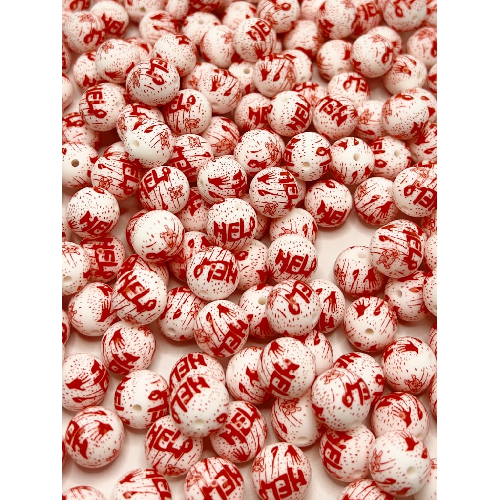 A collection of silicone beads with a white base and red 'BLOOD' text printed on them, simulating a blood splatter pattern.

