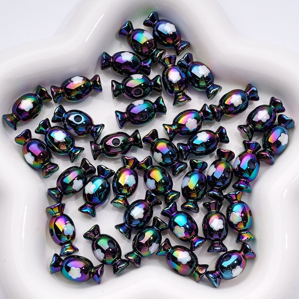 Iridescent candy-shaped beads on a white plate

