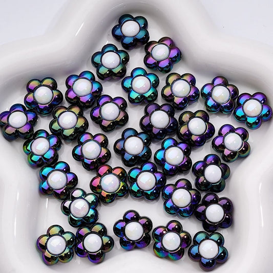 Iridescent flower-shaped beads with white centers on a white surface

