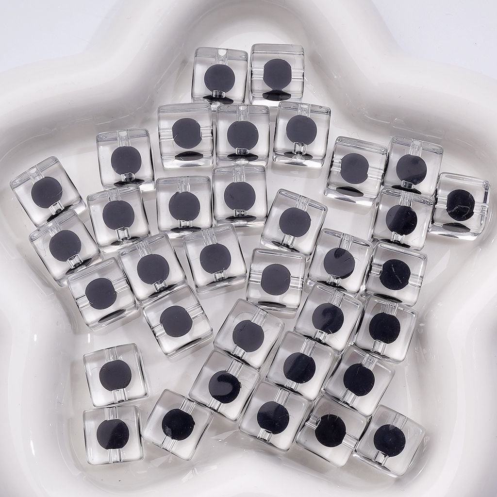 Clear cubes with black circular patterns on a white background

