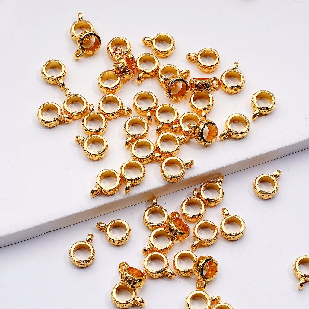 Gold jewelry clasp components on a white surface

