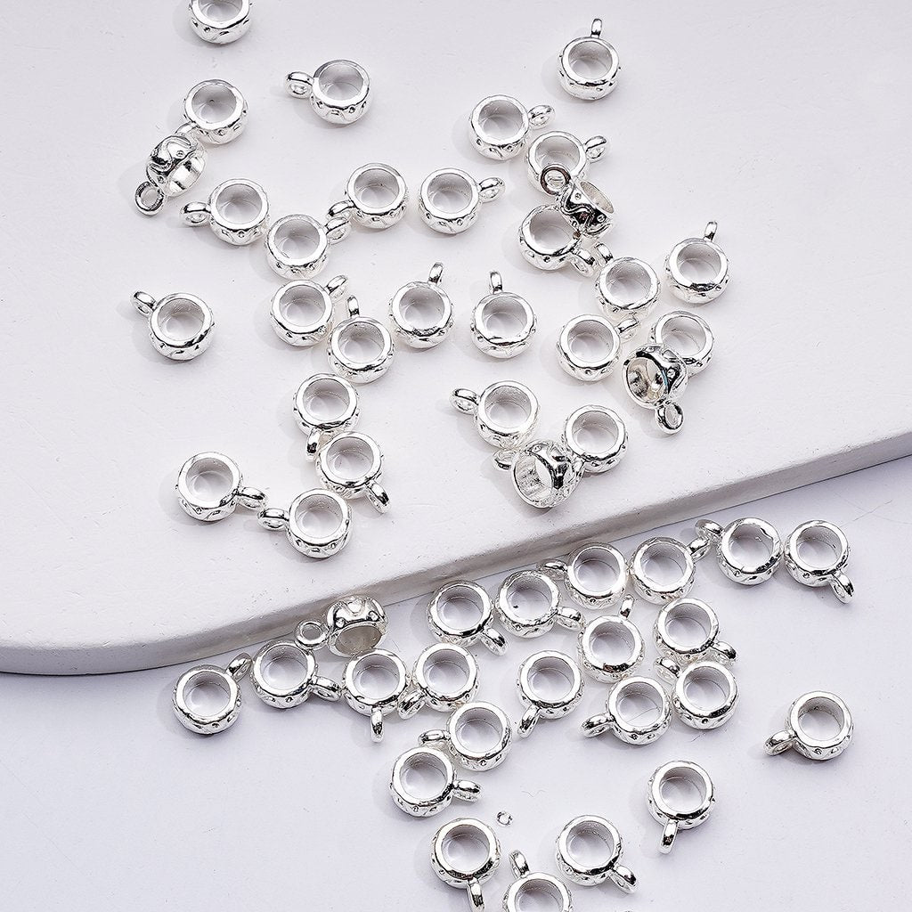 Silver jewelry components on a light gray background

