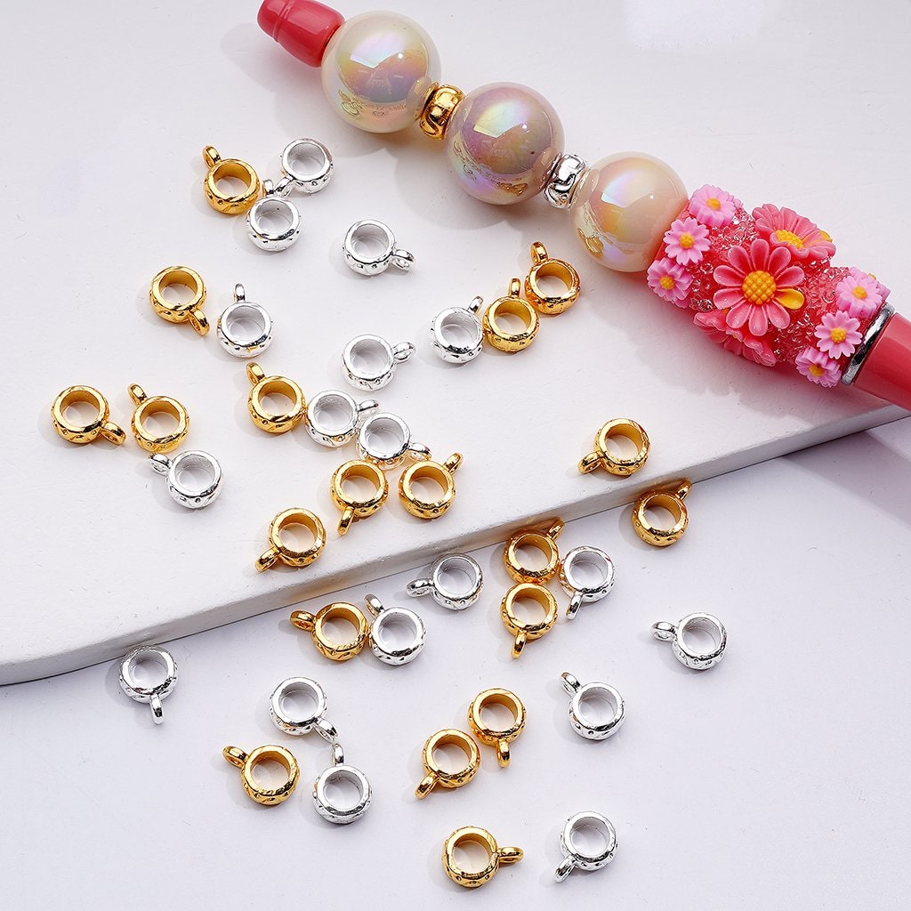 Jewelry clasp connectors in gold, silver, and rose gold on a white background with a floral beaded necklace.

