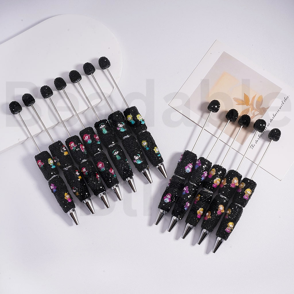 Set of black pens with decorative accents on a white surface

