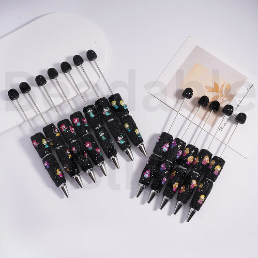 Set of black pens with decorative accents on a white surface

