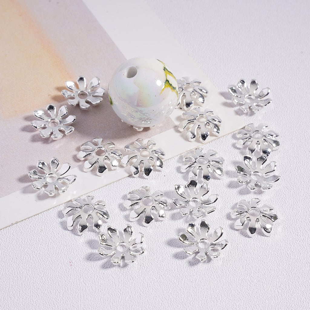Silver flower-shaped beads on a white background