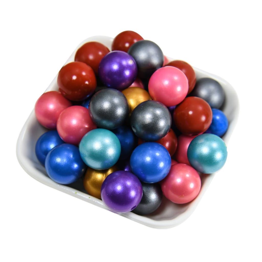 A collection of round silicone beads in various solid colors, including metallic finishes.

