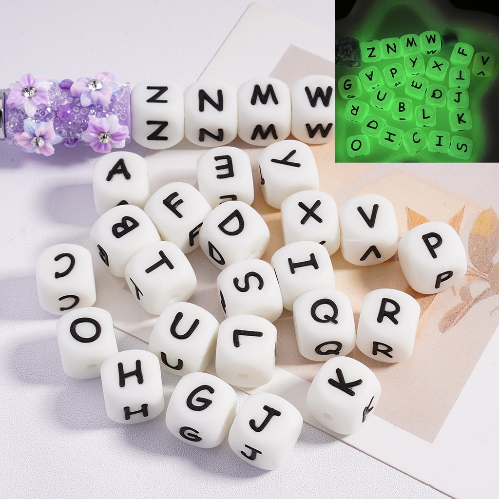 A collection of square silicone beads with letters glowing in green color

