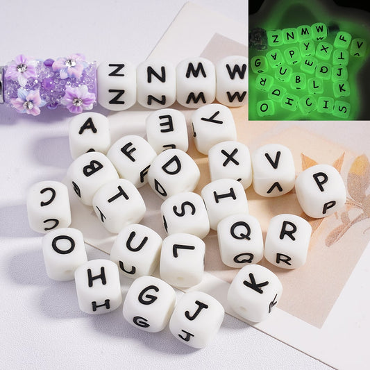 A collection of square silicone beads with letters glowing in green color

