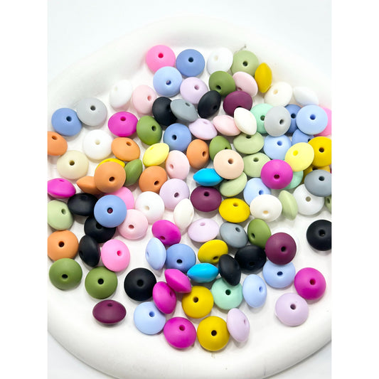 Assorted colorful round beads on a white background


