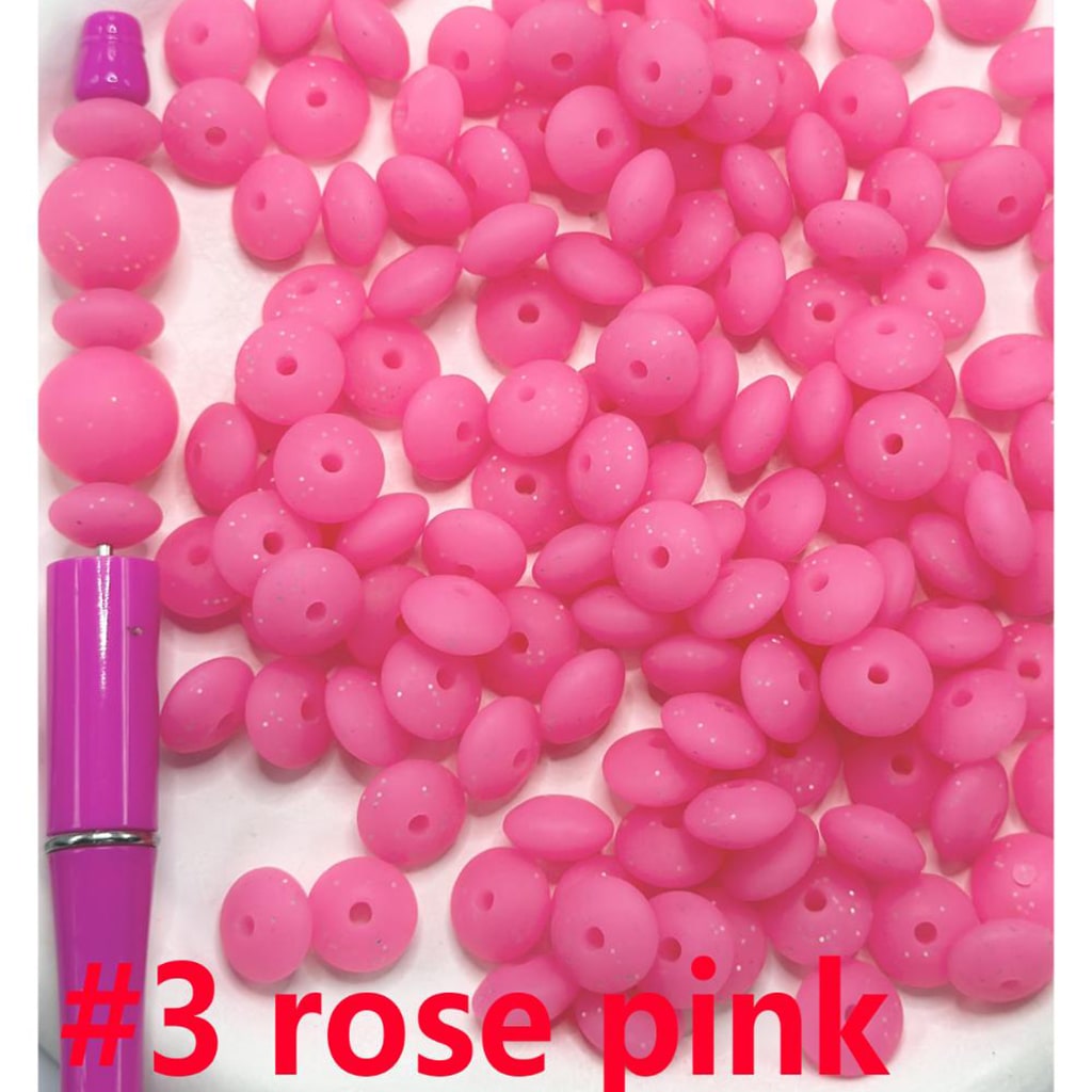 Rose pink beads with a pink tool on a white background


