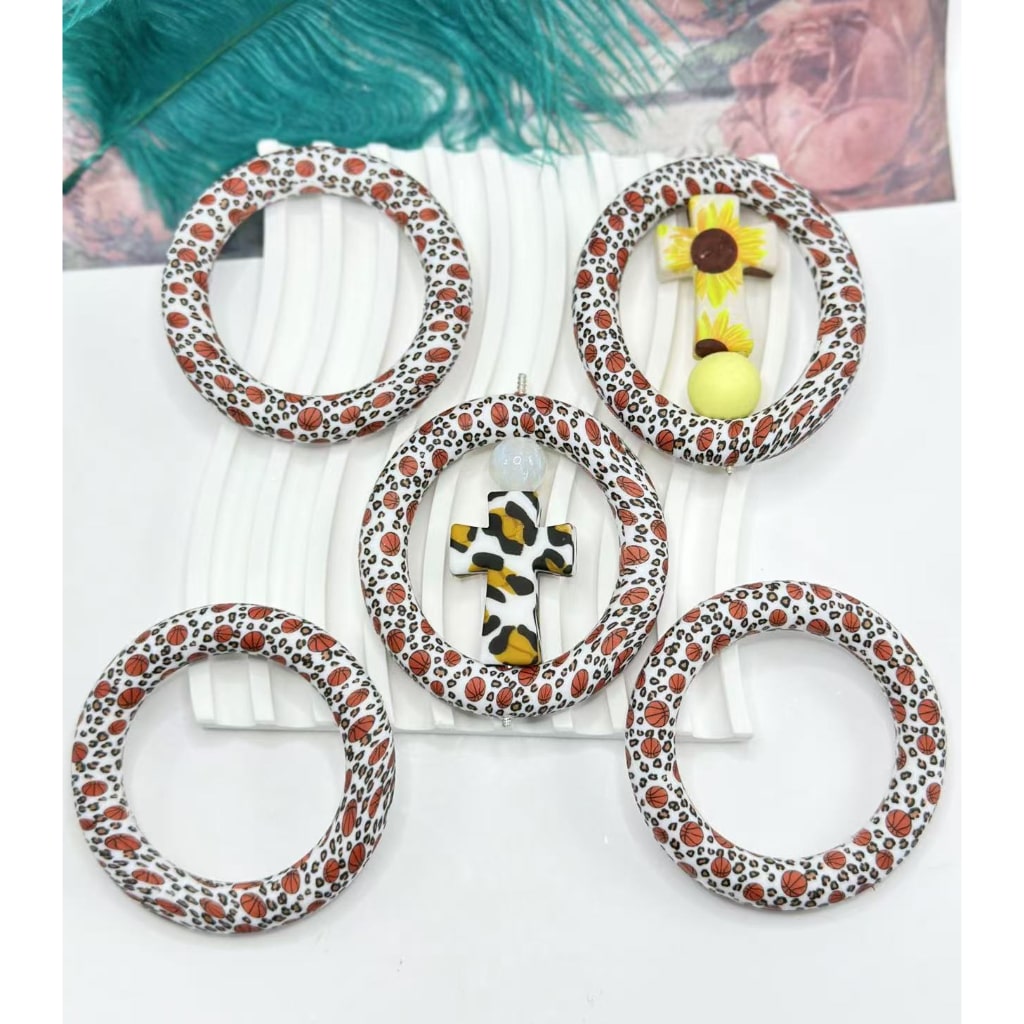 A set of silicone basketball-shaped ring frames with a jaguar animal print design, intended as car hangers or charms.

