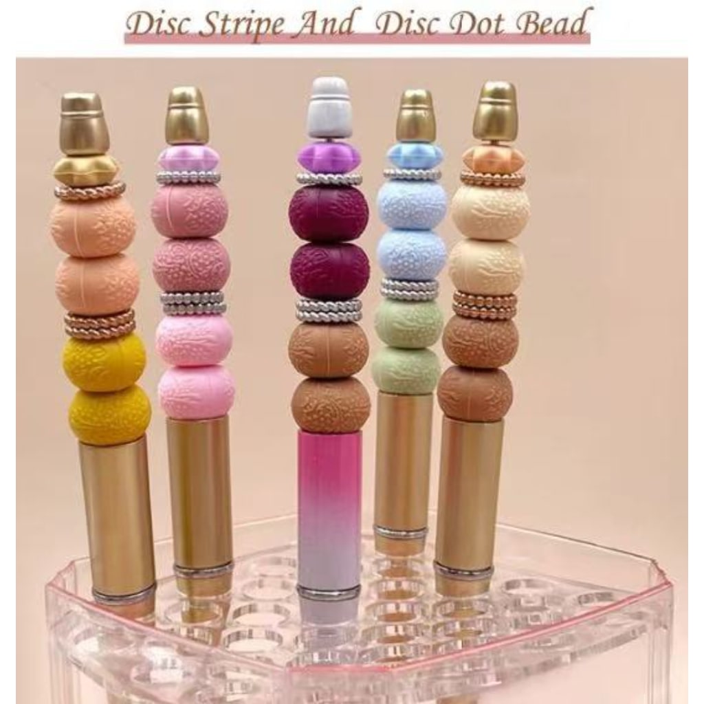A set of multicolored silicone beadable pens with diagonal pattern solid color spacers, displayed in a holder.

