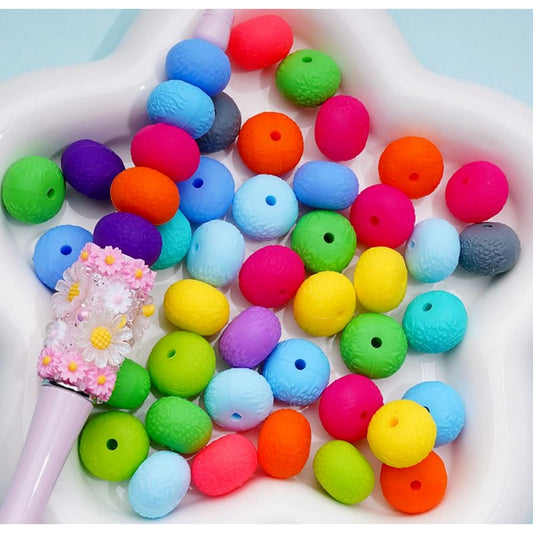 A collection of multicolored round silicone beads in a variety of bright colors, displayed on a surface.

