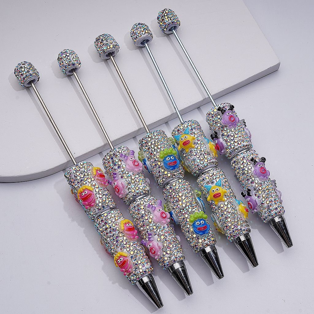 Decorative pens with colorful embellishments on a light gray background

