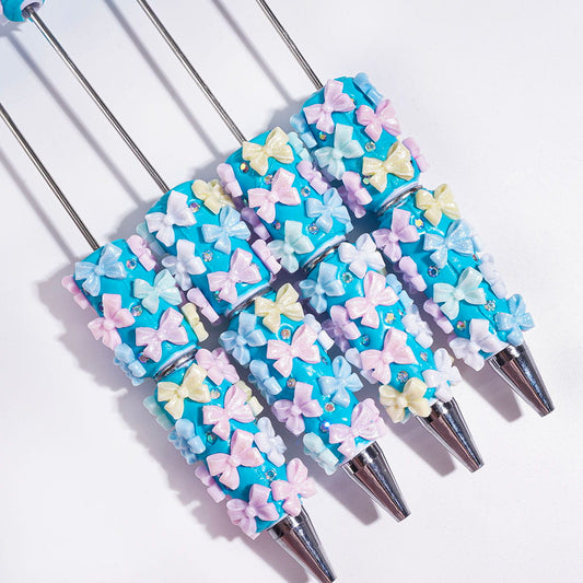 Beadable Clay Pens with Glitter Bowtie and AB Rhinestones on Blue Background